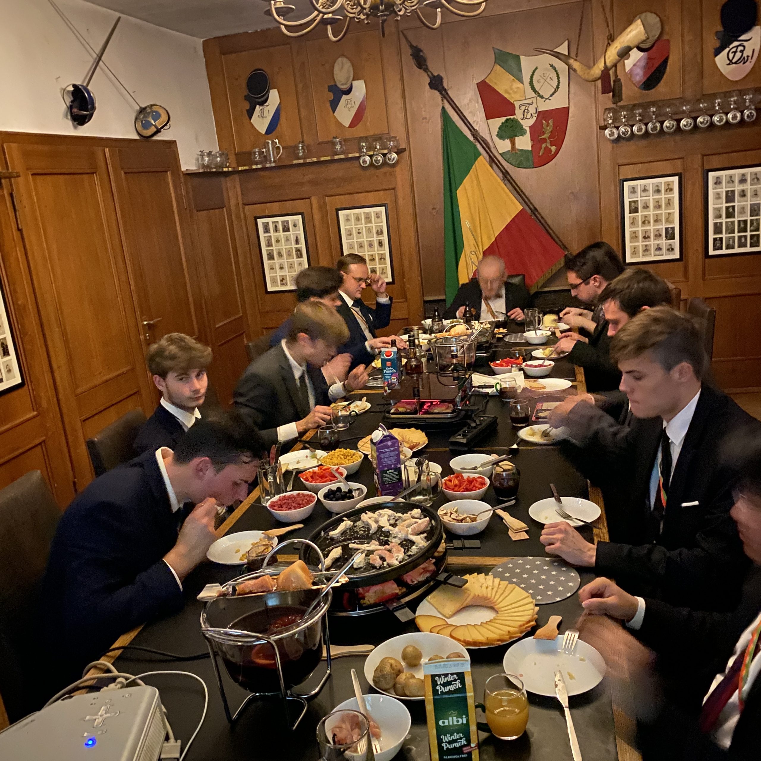 Herren essen am Tisch im Corpshaus in Abendgarderobe